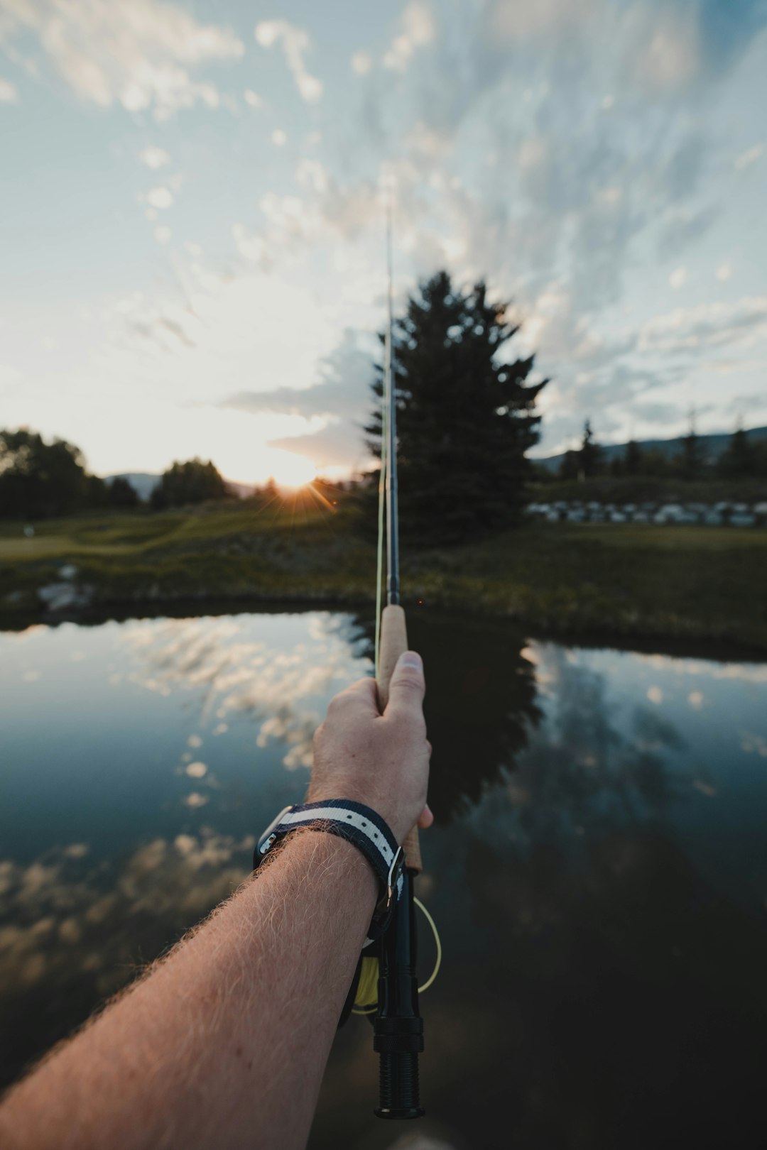 person-holding-silver-and-black-stick-near-lake-during-daytime-mo-rqkngnr0